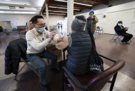 Dr. E. Kwok administers a COVID-19 vaccine to a recipient at a vaccination clinic run by Vancouver Coastal Health, in Richmond, British Columbia, Saturday, April 10, 2021. (Jonathan Hayward/The Canadian Press via AP)