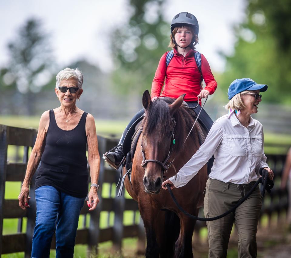 Ephraim Lober enjoys a ride at equestrian therapy nonprofit Saddle Up! in Franklin on July 22, 2023.  Volunteers Fern Aron, left, and Louise Ranaudin assist.