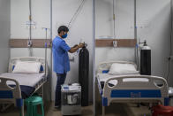 A paramedic make checks an oxygen concentrator at a makeshift COVID-19 care center at an indoor sports stadium in New Delhi, India on Dec. 22, 2021. In India, which has been getting back to normal after a devastating COVID-19 outbreak earlier this year, omicron is once again raising fears, with more than 700 cases reported in the country of nearly 1.4 billion people. (AP Photo/Altaf Qadri)