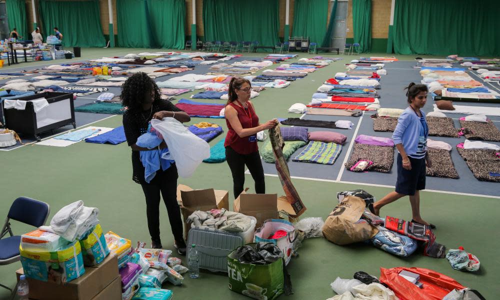 People bring clothing and bedding to Westway sports centre in London, an emergency accommodation centre for people made homeless by the Grenfell Tower fire