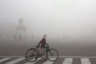 FILE - This Jan. 18, 2019 file photo shows a cyclist amidst morning smog in New Delhi, India. The climate talks in Madrid entered choppier waters Wednesday with ministers struggling to agree on rules for a global carbon market and possible ways to compensate vulnerable countries for disasters caused by global warming.(AP Photo/Manish Swarup, File)