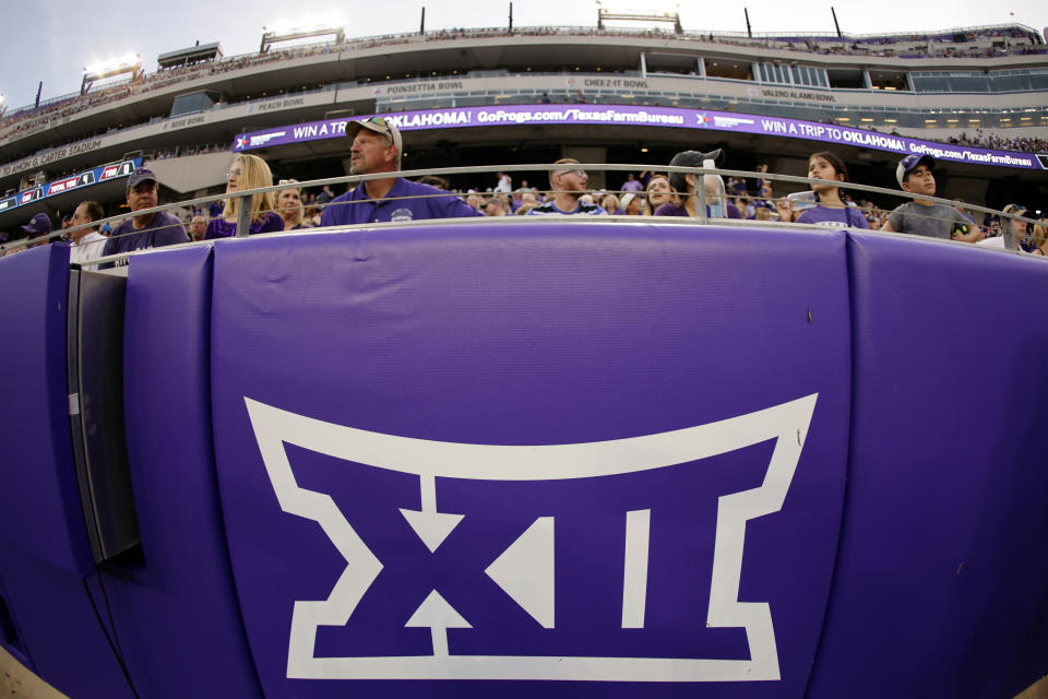 FILE - In this Saturday, Sept. 4, 2021, file photo, a Big 12 Conference logo is displayed on a barrier at Amon G. Carter Stadium before Duquesne played TCU in an NCAA college football game in Fort Worth, Texas. The Big 12 has extended membership invitations to BYU, UCF, Cincinnati and Houston to join the Power Five league. That comes in advance of the league losing Oklahoma and Texas to the Southeastern Conference. (AP Photo/Ron Jenkins, File)