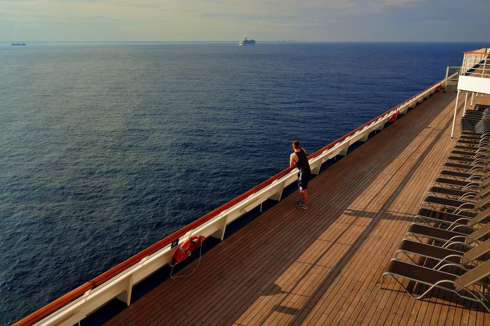 A man looks over the sea from the top deck of a cruise ship off the coast of the island of Cozumel, Mexico