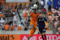 Houston Dynamo's Teenage Hadebe, left, goes up to head the ball in front of Chicago Fire's Brian Gutiérrez (40) during the first half of an MLS soccer game Saturday, June 25, 2022, in Houston. (AP Photo/David J. Phillip)