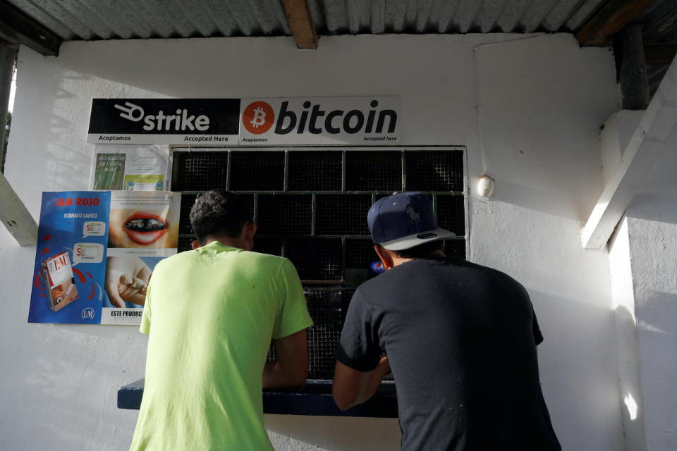 Men buy snacks at a store where bitcoins are accepted at El Zonte Beach in Chiltiupan, El Salvador June 16, 2021. REUTERS/Jose Cabezas - RC2Z1O9MEUEP