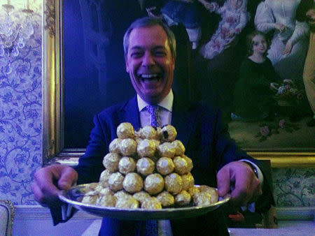 Nigel Farage, the interim leader of the United Kingdom Independence Party (UKIP) holds a platter of Ferrero Rocher chocolates during a party in London, Britain, November 23, 2016. REUTERS/Guy Faulconbridge