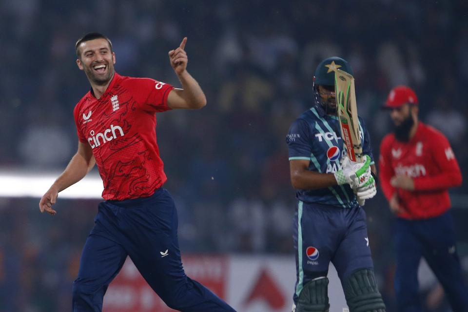England's Mark Wood, left, celebrates after taking the wicket of Pakistan's Babar Azam, center, during the fifth twenty20 cricket match between Pakistan and England, in Lahore, Pakistan, Wednesday, Sept. 28, 2022. (AP Photo/K.M. Chaudary)