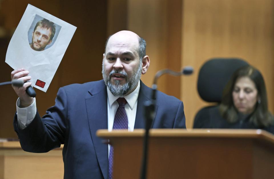 Senior Assistant New Hampshire Attorney General Benjamin Agati shows the jury a photograph of the defendant during closing arguments in Adam Montgomery's trial, Wednesday, Feb. 21, 2024, in Manchester, N.H. Montgomery is accused of killing his 5-year-old daughter Harmony. (Jim Davis/The Boston Globe via AP, Pool)