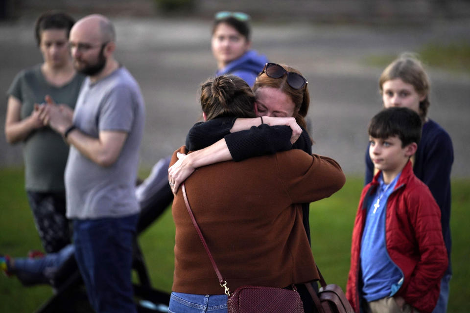 FILE - Lindsay Marlow, facing camera, hugs Courtney Majoros at a vigil in Lisbon Falls, Maine, for the victims of recent mass shootings, Oct. 28, 2023. Majoros' brother, Max Hathaway, was one of the people killed in separate shootings in nearby Lewiston, Maine. (AP Photo/Robert F. Bukaty, File)