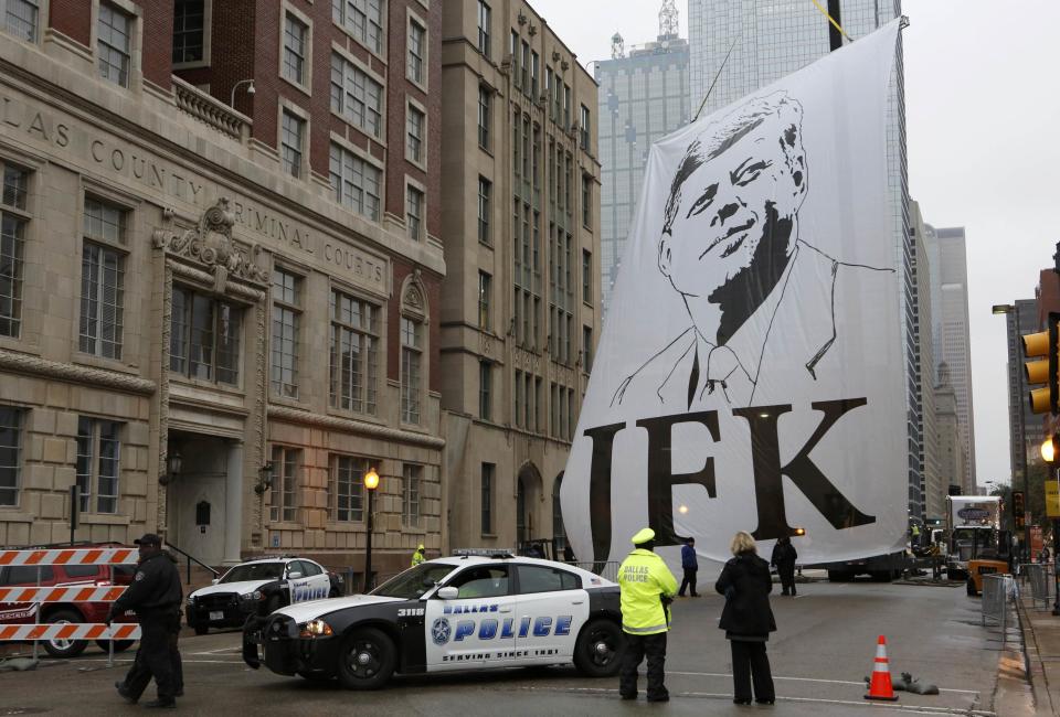 A banner of President John F. Kennedy is pulled into place in Dealey Plaza prior to 50th anniversary ceremonies of JFK's assassination in Dallas