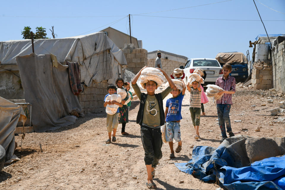 Children receive bread distributed by relief organizations in refugee camps in Aqrabat in Idlib countryside, northwest Syria, Idlib, on august 28, 2022. / Credit: Rami Alsayed/NurPhoto via Getty Images