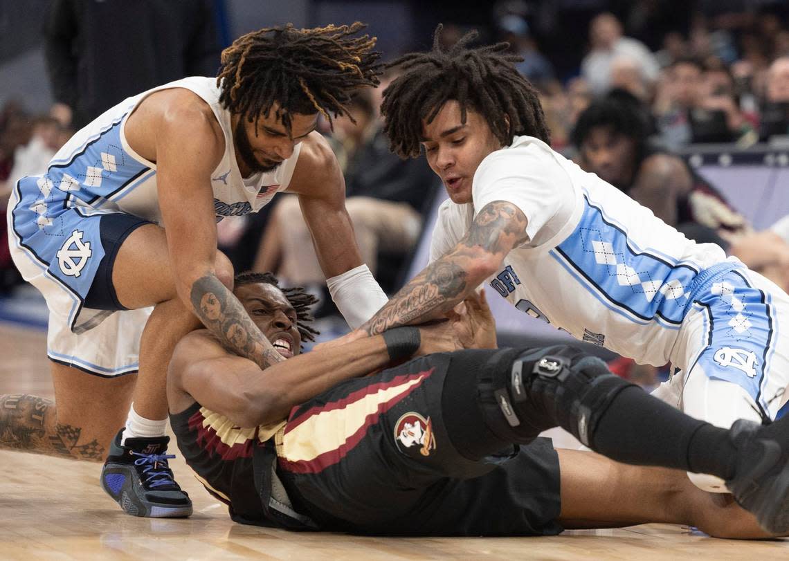 North Carolina’s R.J. Davis (4) and Elliot Cadeau (2) battle for a loose ball with Florida State’s Jaylan Gainey (33) in the first half in the quarterfinals of the ACC Men’s Basketball Tournament at Capitol One Arena on Wednesday, March 13, 2024 in Washington, D.C.