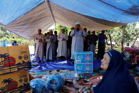 Villagers hold evening prayer inside a temporary shelter after an earthquake hit Lombok island in Pamenang, Indonesia August 6, 2018. REUTERS/Beawiharta