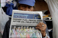 A sidewalk vendor reads a newspaper that headlines the recent attacks of Saudi oil refinery and raises global concern for a possible spike of oil prices Tuesday, Sept. 17, 2019, in Manila, Philippines. Monday saw another round of oil price increase in the country which energy officials said is not related to the recent attacks in Saudi Arabia but has cautioned the public to brace for more spikes in the coming days. (AP Photo/Bullit Marquez)