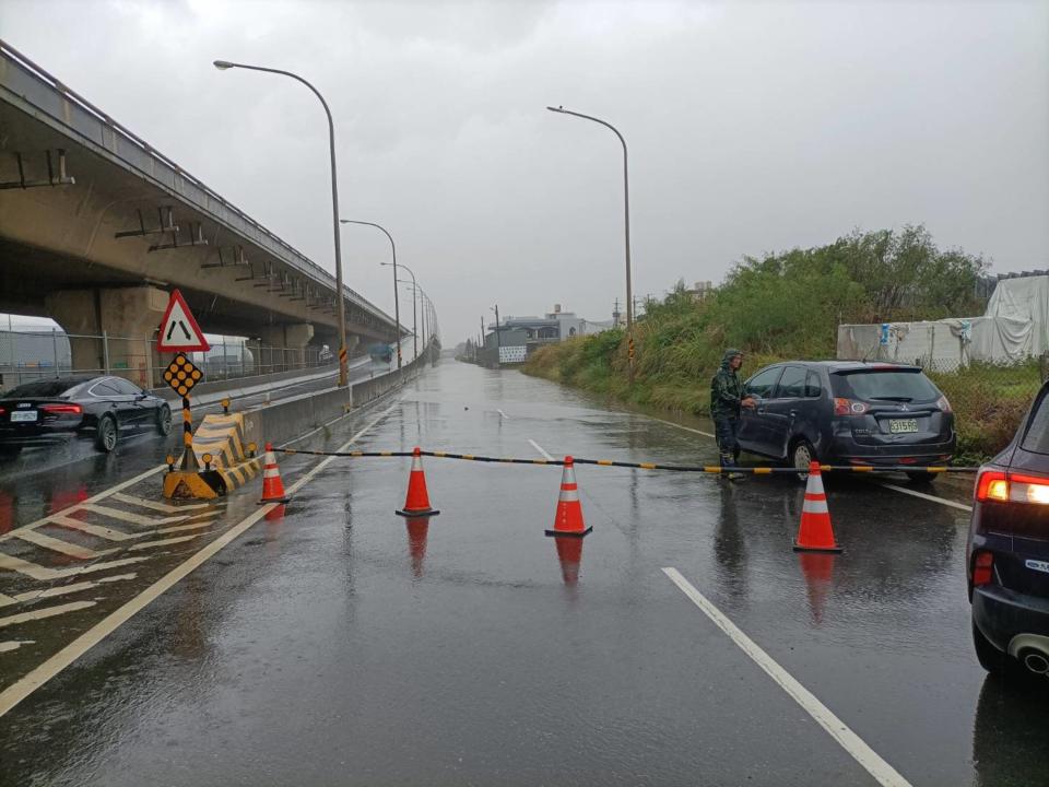 桃園強降雨，觀音區台61線北上平面道路與忠孝路口嚴重積水，警方擺設交通連桿、交通錐執行交通管制。（圖／桃園市警察局提供）