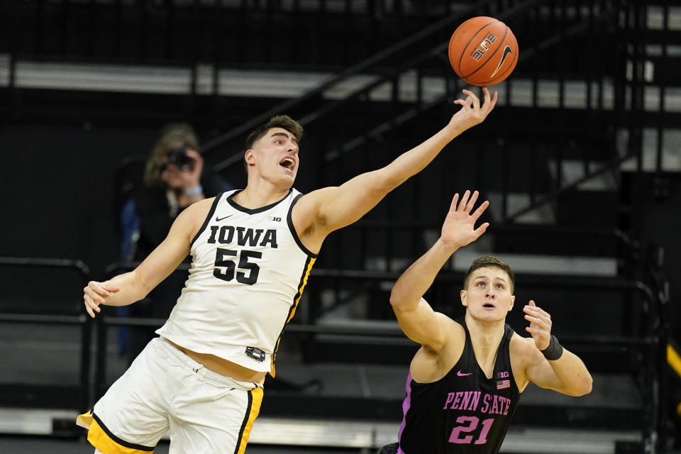 Iowa center Luka Garza (55) grabs a rebound over Penn State forward John Harrar during the first half of an NCAA college basketball game, Sunday, Feb. 21, 2021, in Iowa City, Iowa. (AP Photo/Charlie Neibergall)