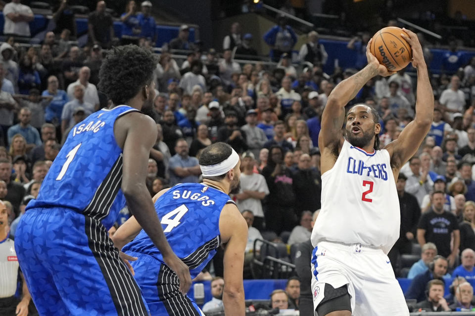 Los Angeles Clippers forward Kawhi Leonard (2) makes a shot over Orlando Magic forward Jonathan Isaac (1) and guard Jalen Suggs (4) during the second half of an NBA basketball game, Friday, March 29, 2024, in Orlando, Fla. (AP Photo/John Raoux)