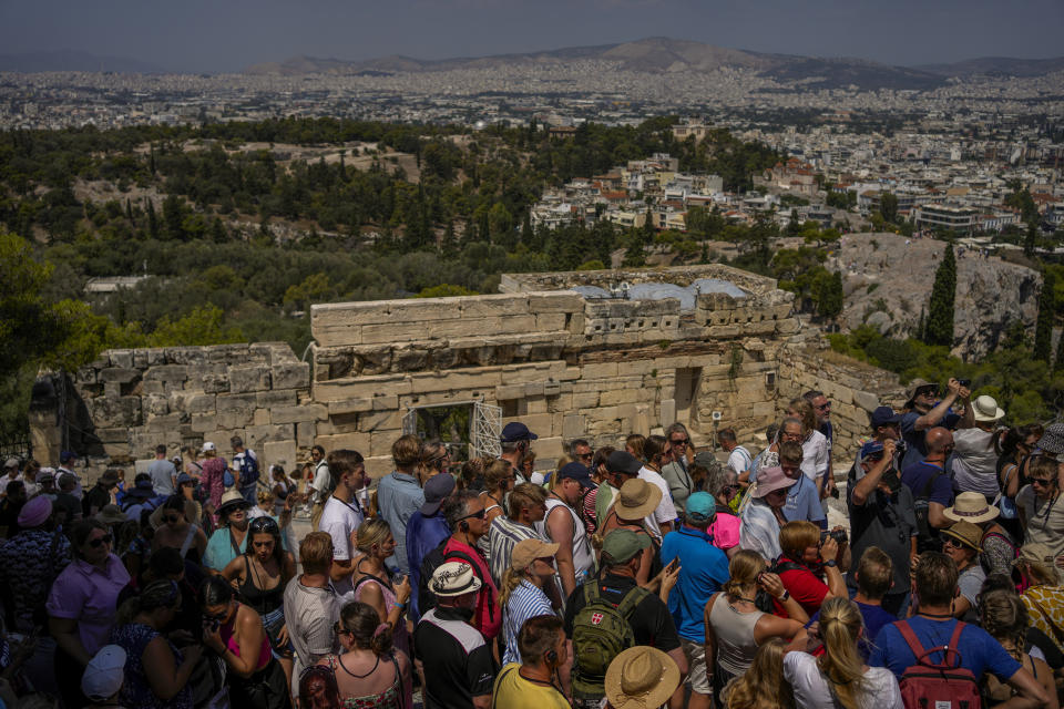 Tourists visit the Acropolis ancient hill, in Athens, Greece, Tuesday, July 4, 2023. Crowds are packing the Colosseum, the Louvre, the Acropolis and other major attractions as tourism exceeds 2019 records in some of Europe’s most popular destinations. While European tourists helped the industry on the road to recovery last year, the upswing this summer is led largely by Americans, who are lifted by a strong dollar and in some cases pandemic savings. (AP Photo/Thanassis Stavrakis)