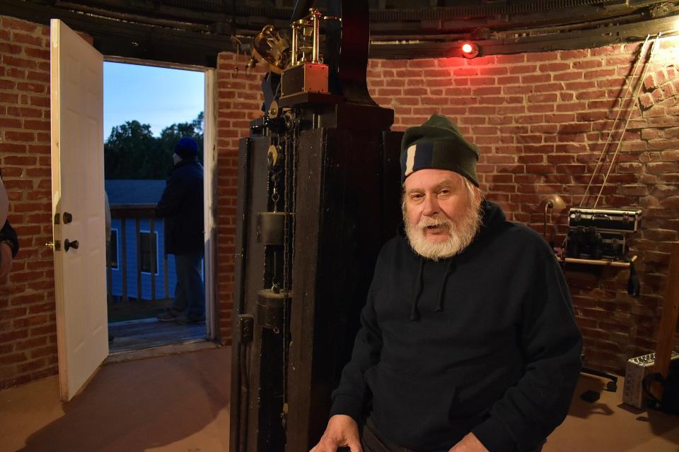 Steve Siok sits under the observatory's Alvan Clark telescope just before nightfall, when guests arrive.