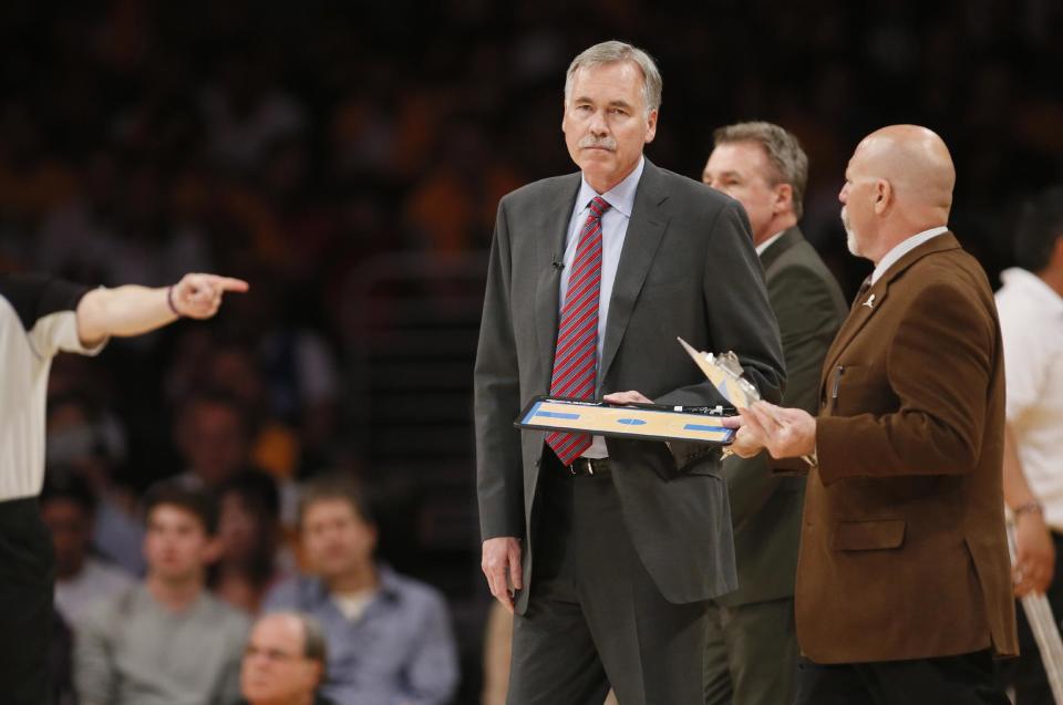 Los Angeles Lakers head coach Mike D'Antoni gets his clipboard from athletic trainer Gary Vitti during a time out against the Oklahoma City Thunder in the first half of an NBA basketball game in Los Angeles, Sunday, March 9, 2014. (AP Photo/Danny Moloshok)
