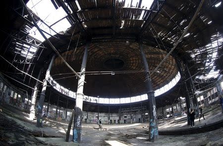 People walk at an abandoned freight station in Pankow in Berlin March 9, 2015. REUTERS/Fabrizio Bensch