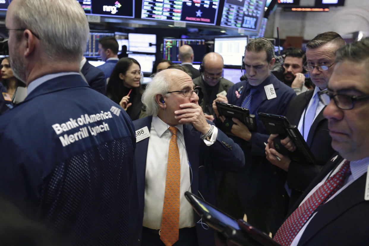 A wave of selling hit U.S. equity funds at the end of March. Trader Peter Tuchman, center, stands on the floor of the New York Stock Exchange. (AP Photo/Richard Drew)