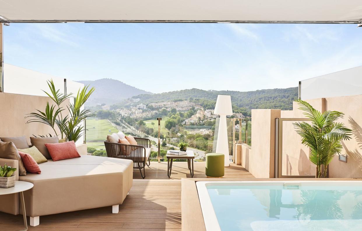 a pool and a couch in a room with a view of the mountains