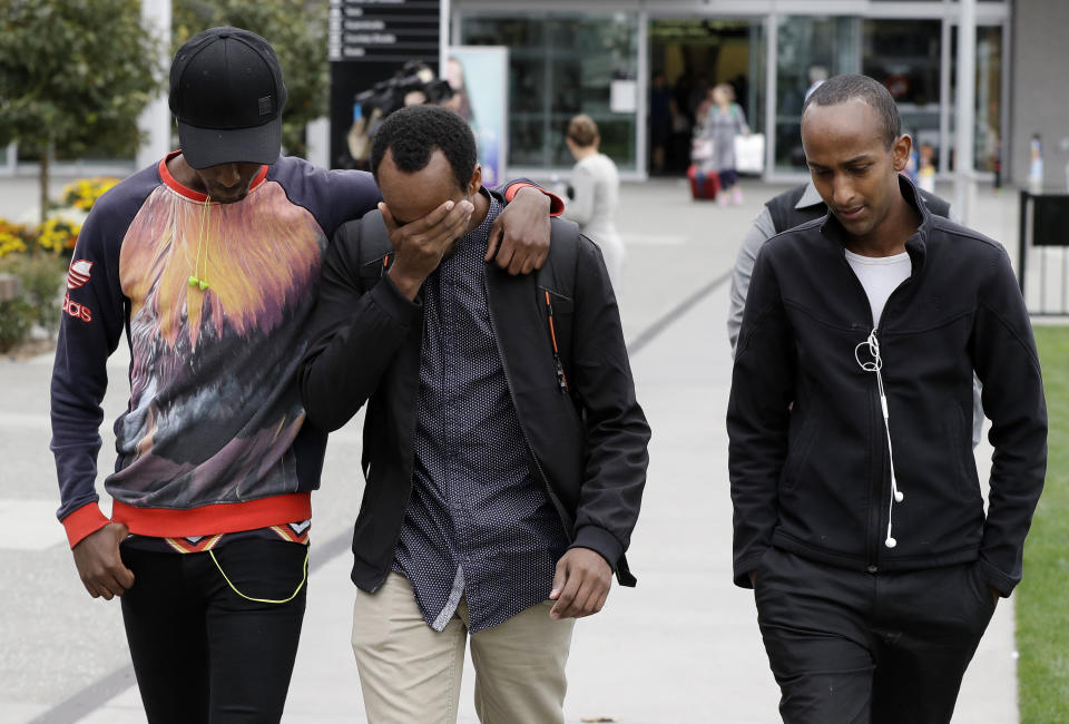 Abdifatah Ibrahim, center, and his brother Abdi, right, walk with an unidentified friend in Christchurch, New Zealand, Sunday, March 17, 2019. Abdifatah and Abdi are the older brothers of three-year-old Mucaad, who is the youngest known victim of the mass shooting in Christchurch, New Zealand on Friday, March 15. (AP Photo/Mark Baker)