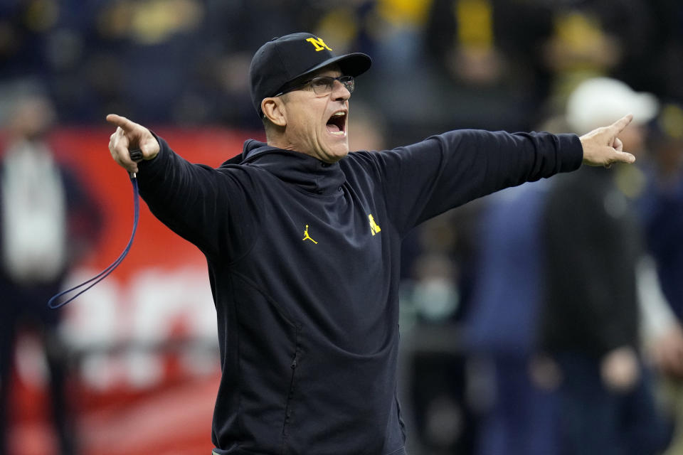 Michigan head coach Jim Harbaugh directs his team during warmups before the Big Ten championship NCAA college football game against Iowa, Saturday, Dec. 4, 2021, in Indianapolis. (AP Photo/AJ Mast)