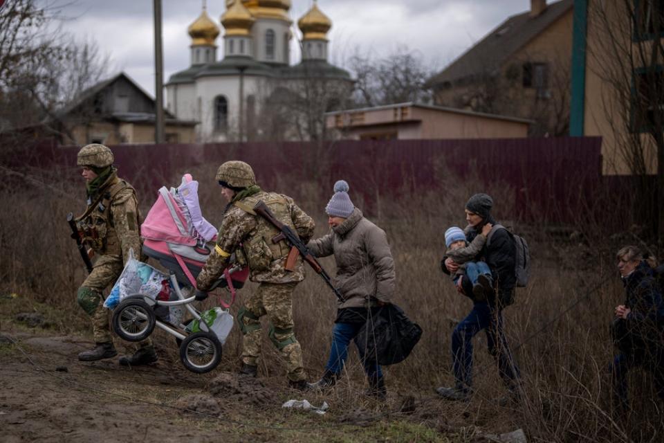 Ukrainian soldiers help a fleeing family crossing the Irpin river on the outskirts of Kyiv, Ukraine (Copyright 2019 The Associated Press. All rights reserved)