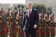 Canada's Prime Minister Stephen Harper review Bedouin honour guards during Harper's visit to Jordan at the Royal Palace in Amman January 23, 2014. REUTERS/Muhammad Hamed (JORDAN - Tags: POLITICS MILITARY)