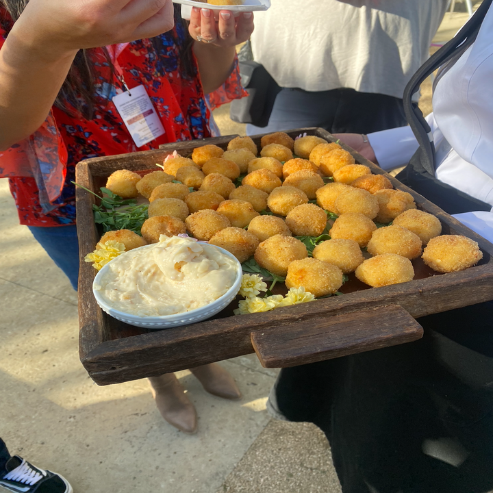 Someone holding out food for guests