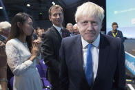 Boris Johnson walks to the stage, as rival Jeremy Hunt looks on after the announcement of the result in the ballot for the new Conservative party leader, in London, Tuesday, July 23, 2019. Brexit hardliner Boris Johnson won the contest to lead Britain's governing Conservative Party on Tuesday and will become the country's next prime minister, tasked with fulfilling his promise to lead the U.K. out of the European Union "come what may." (Stefan Rousseau/Pool photo via AP)