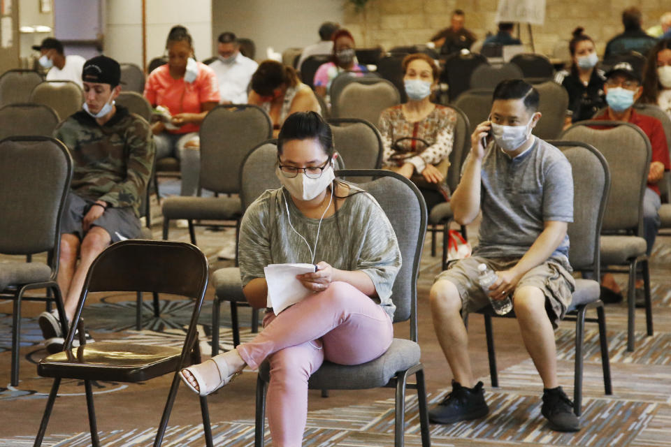 People wait to speak with representatives from the Oklahoma Employment Security Commission about unemployment claims Thursday, July 9, 2020, in Midwest City, Okla. The OESC has been hosting multiple days of in-person, socially-distanced claim processing events for individuals needing help with their claims. (AP Photo/Sue Ogrocki)