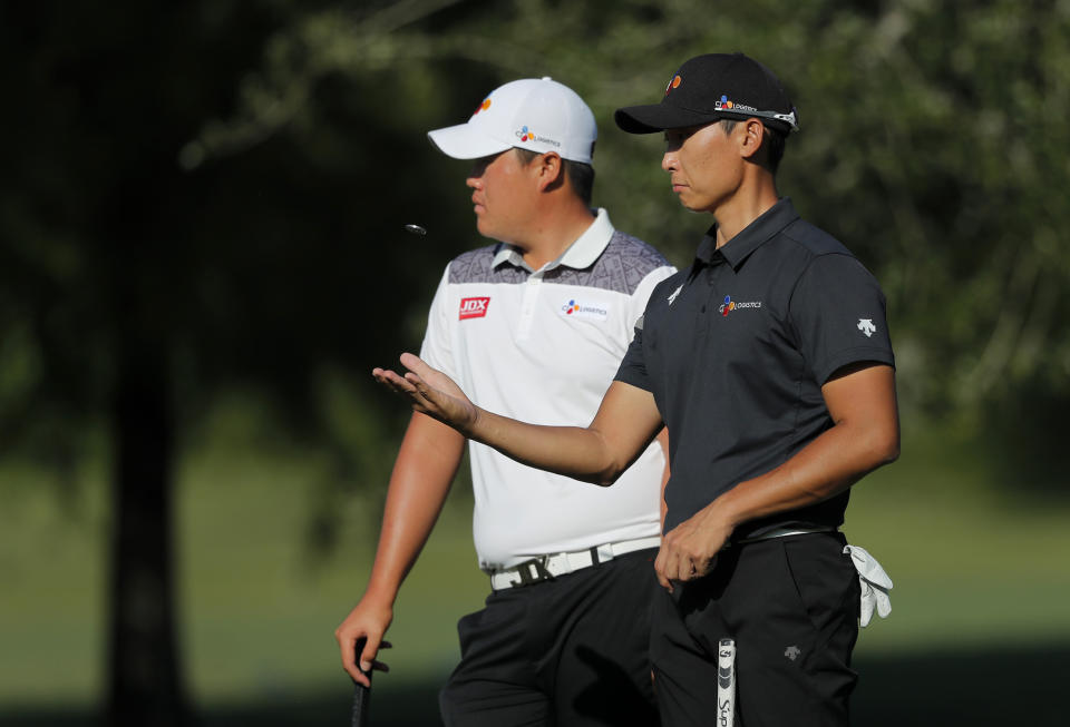 Sungjae Im, left, and Whee Kim, both of South Korea wait for their turn to putt on the first green, during the first round of the PGA Zurich Classic golf tournament at TPC Louisiana in Avondale, La., Thursday, April 25, 2019. (AP Photo/Gerald Herbert)