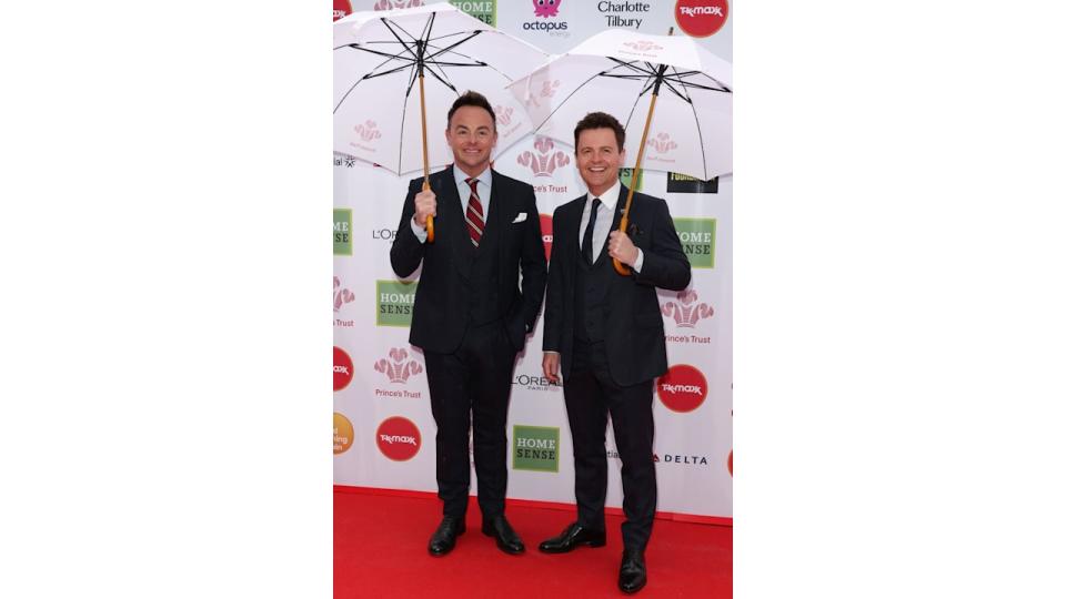 Ant and Dec in suits holding umbrellas