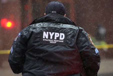 New York City Police Department (NYPD) officer arrives at 787 7th Avenue in midtown Manhattan where helicopter crashed in New York