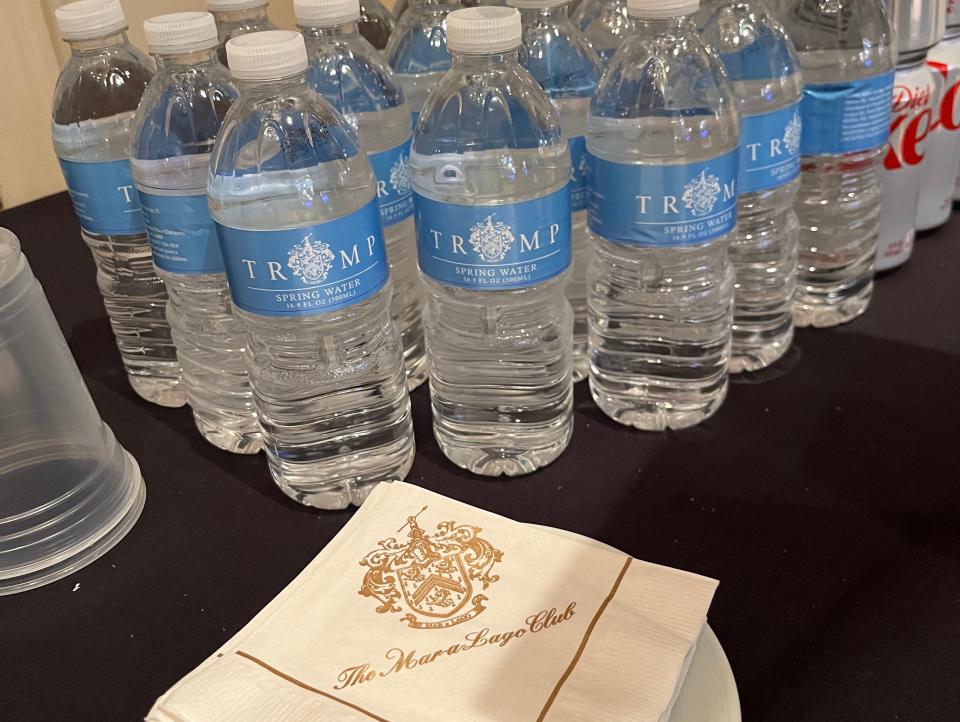 Mar-a-Lago emblazoned napkins next to Trump-branded water bottles.