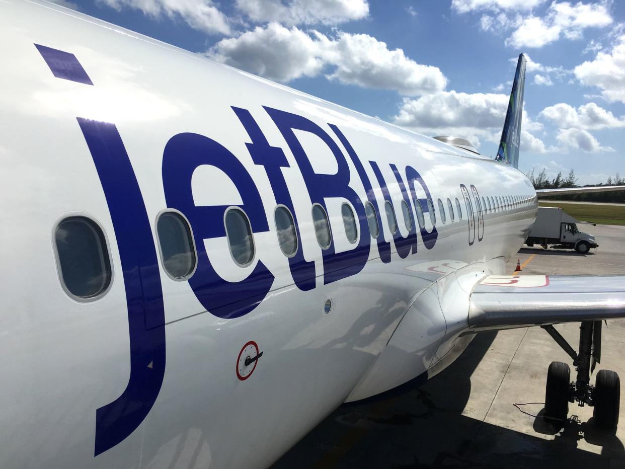 George Town, Cayman Islands - December 21, 2017: Land operations and boarding in Owen Roberts Intl. Airport in Grand Cayman Islands. Close up of a JetBlue plane in a sunny day.
