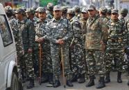 Indian security personnel stand guard near a religious procession being held to mark Eid-e-Milad-ul-Nabi, or birthday celebrations of Prophet Mohammad, in the old quarters of Delhi January 14, 2014. REUTERS/Anindito Mukherjee (INDIA - Tags: RELIGION SOCIETY)