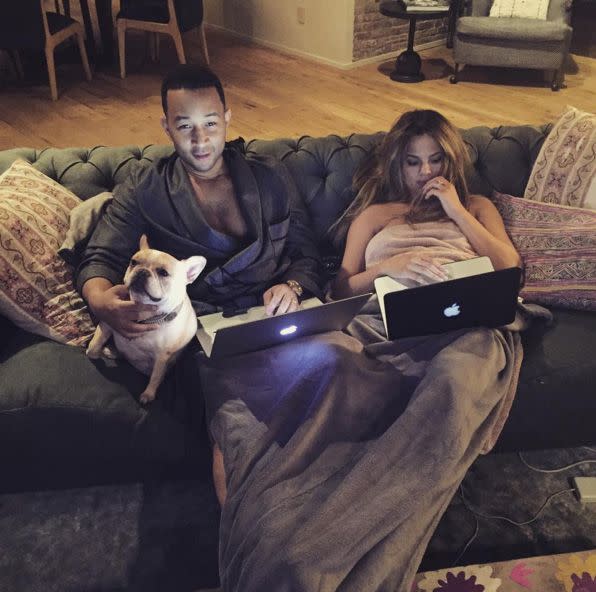 The couple lounges with their laptops and French bulldog in an Instagram captioned, 