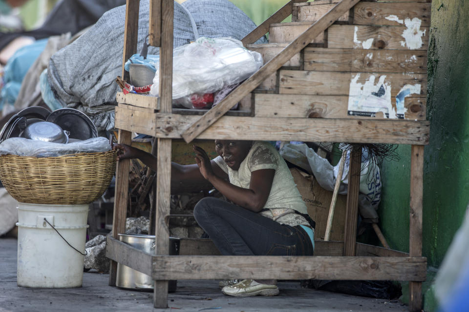 A street vendor hides during clashes between protesters and national police officers as the protestors demanded the resignation of President Jovenel Moise in Port-au-Prince, Haiti, Feb. 9, 2019. The image was part of a series of photographs by Associated Press photographers which was named a finalist for the 2020 Pulitzer Prize for Breaking News Photography. (AP Photo/Dieu Nalio Chery)