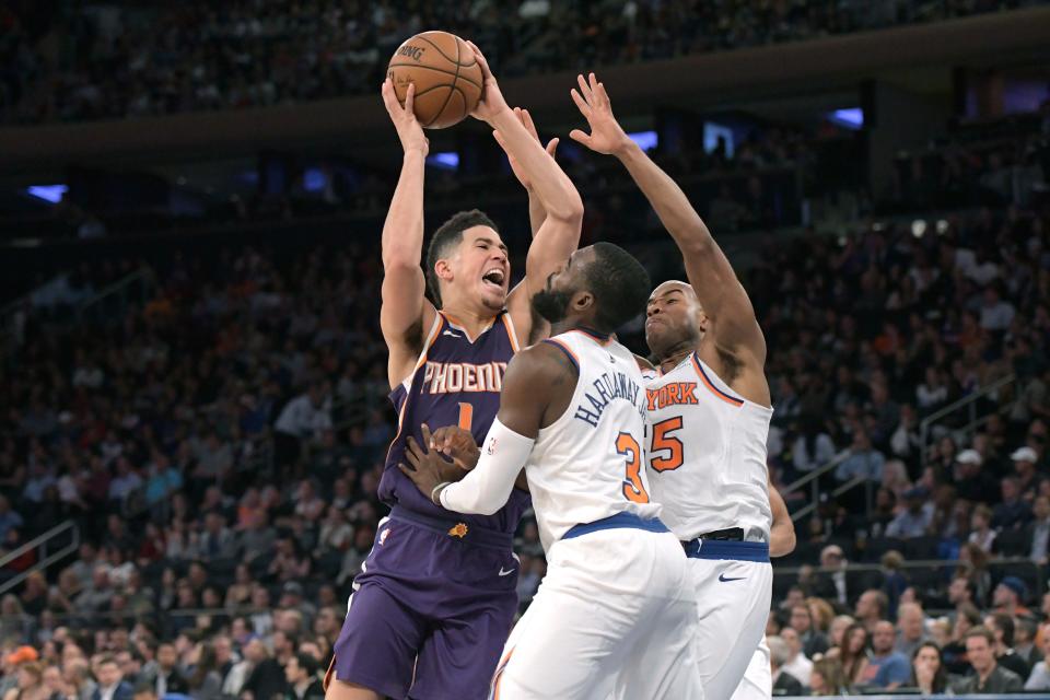 Phoenix Suns guard Devin Booker, left, is pressured by New York Knicks forward Tim Hardaway Jr. (3) and guard Jarrett Jack during the third quarter of an NBA basketball game Friday, Nov. 3, 2017, at Madison Square Garden in New York. The Knicks won 120-107. (AP Photo/Bill Kostroun)