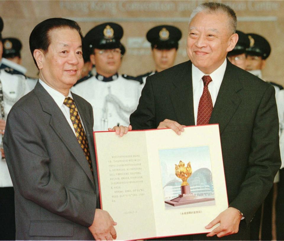 FILE - In this file photo taken Tuesday, July 1, 1997, then Hong Kong's newly inaugurated Chief Executive Tung Chee-hwa, right, receives a book bearing a picture of a statue from then Chinese Foreign Minister Qian Qichen during a ceremony in Hong Kong. On July 1, 1997, Tung Chee-Hwa, the first chief executive of Hong Kong, declared: "For the first time in history, we, the people of Hong Kong, will be master of our own destiny." (Pool Photo via AP Photo, File)