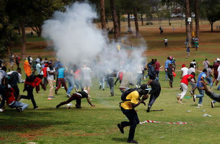 Protesters take cover as police fire stun grenades to disperse hundreds of students demanding free university education, outside South African President Jacob Zuma's offices, in Pretoria, South Africa October 20,2016. REUTERS/Siphiwe Sibeko