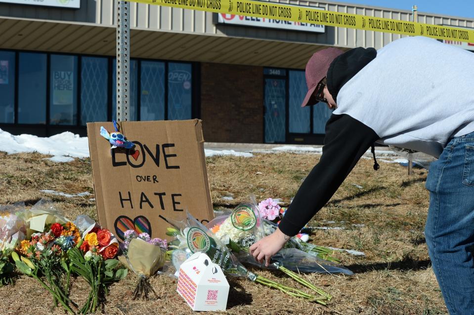 Elijah Newcomb of Colorado Springs lays flowers near a gay nightclub in Colorado Springs, Colo., Sunday, Nov. 20, 2022 where a shooting occurred late Saturday night. (AP Photo/Geneva Heffernan)