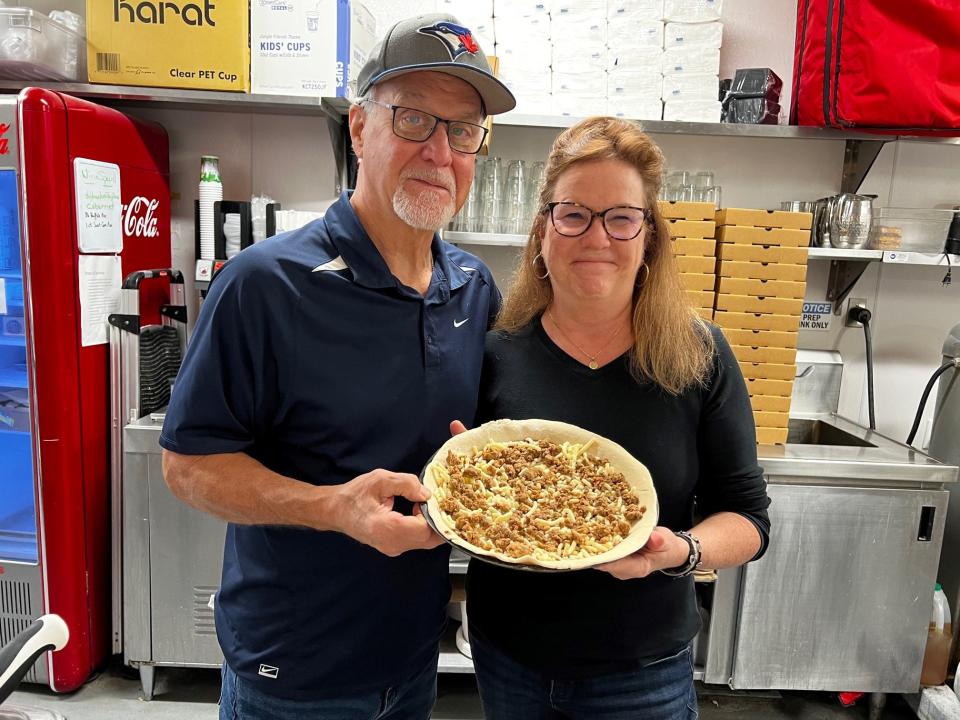 Ron and Ann Bonanno prepare one of the Bamie's pizzas in the kitchen at Gusto Pizza Bar.