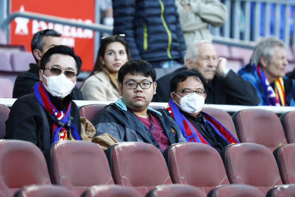 Barcelona fans wear face masks in an attempt to protect there self from the coronavirus, prior a Spanish La Liga soccer match between Barcelona and Real Sociedad at the Camp Nou stadium in Barcelona, Spain, Saturday, March 7, 2020. (AP Photo/Joan Monfort)