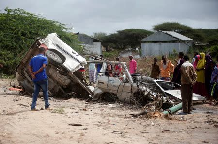 Residents gather to look at the wreckage of a minibus destroyed in roadside bomb in Lafoole village near Somalia's capital Mogadishu, June 30, 2016. REUTERS/Feisal Omar