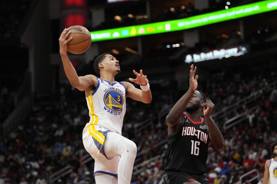 Golden State Warriors' Jordan Poole (3) goes up for a shot as Houston Rockets' Usman Garuba (16) defends during the second half of an NBA basketball game Monday, March 20, 2023, in Houston. The Warriors won 121-108. (AP Photo/David J. Phillip)